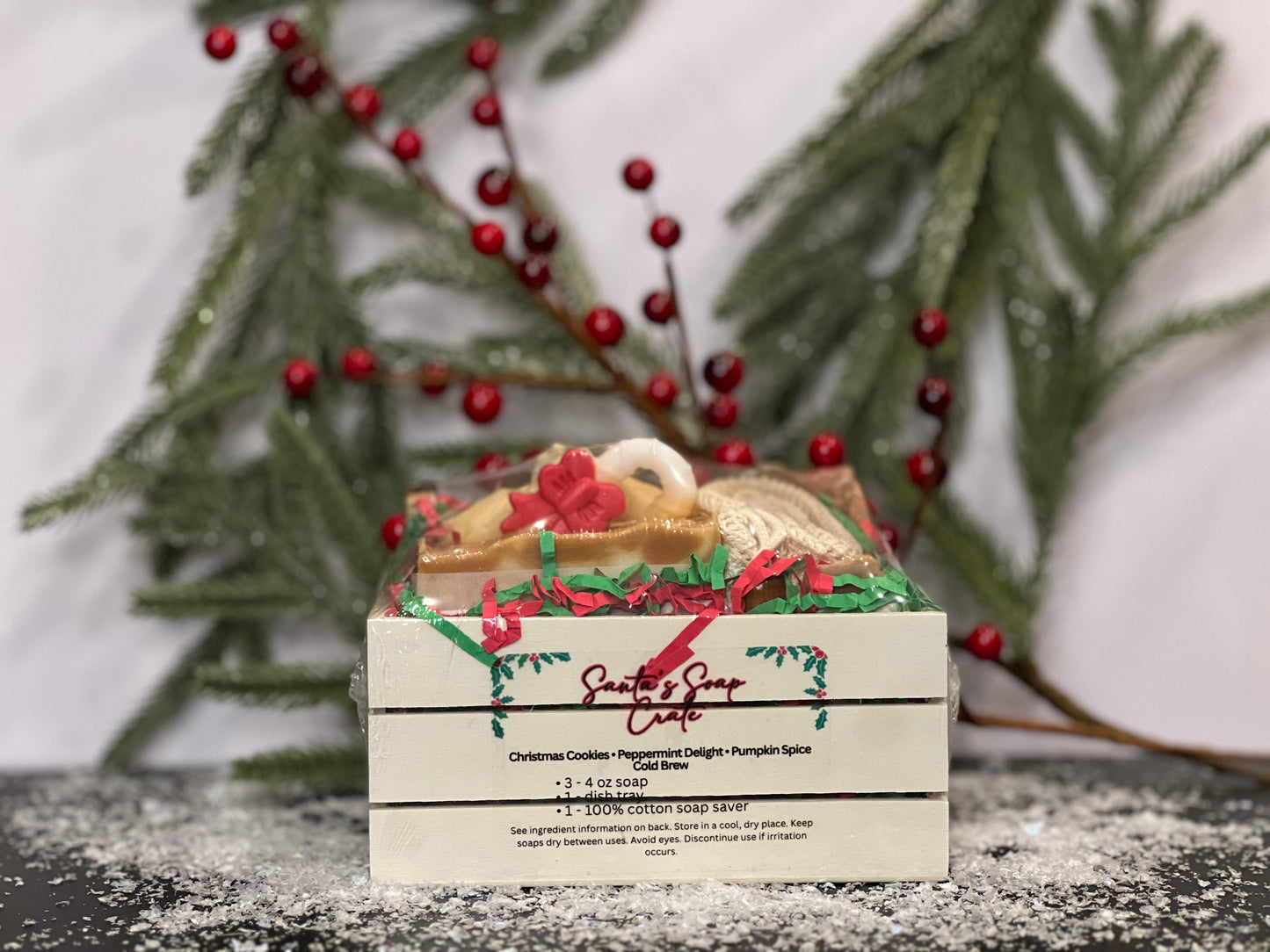 Soap in a small crate with Fall and Christmas designs and scents, with a white background, berries, tree foliage and snow decorations. 