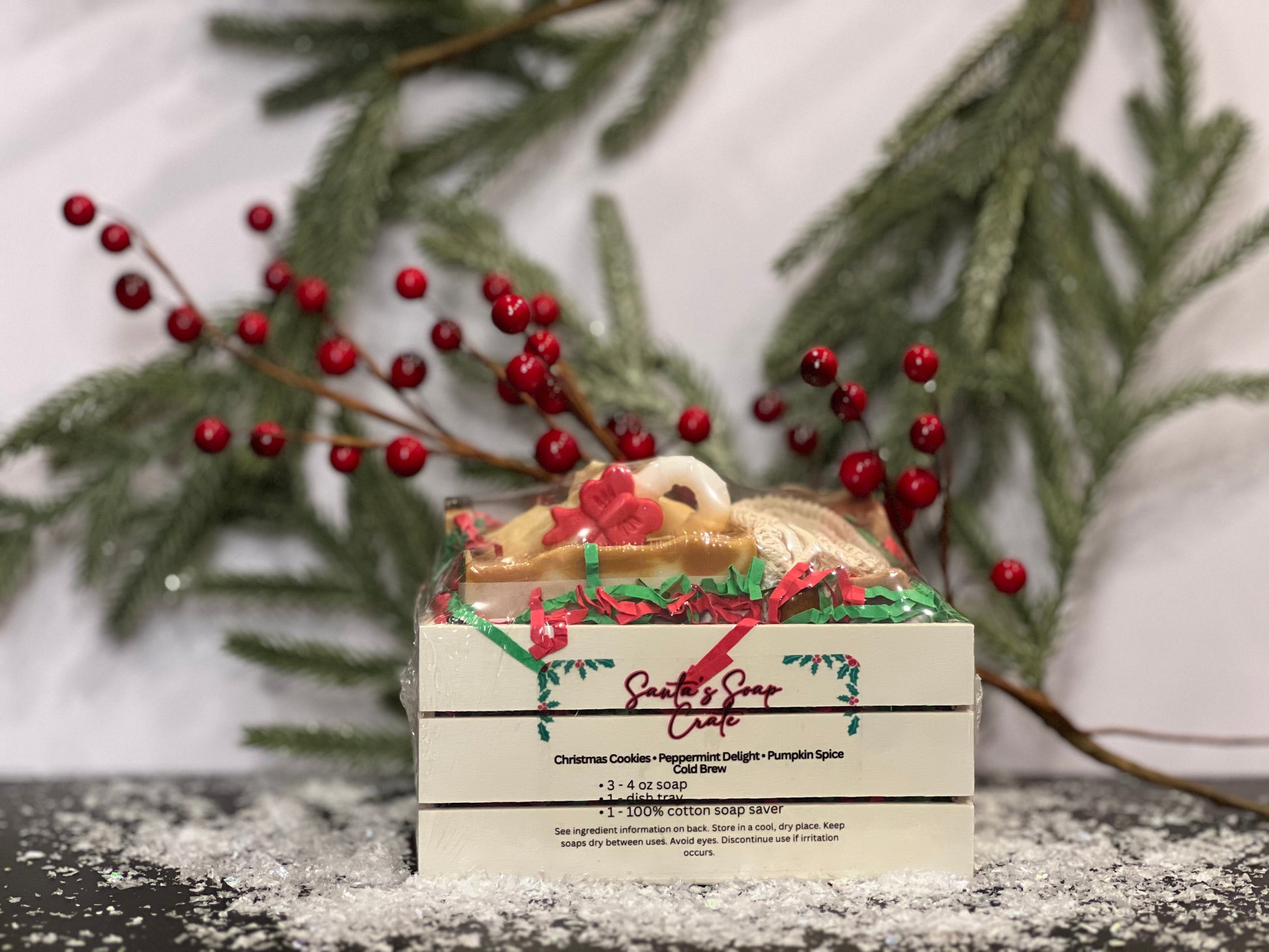 Soap in a small crate with Fall and Christmas designs and scents, with a white background, berries, tree foliage and snow decorations. 